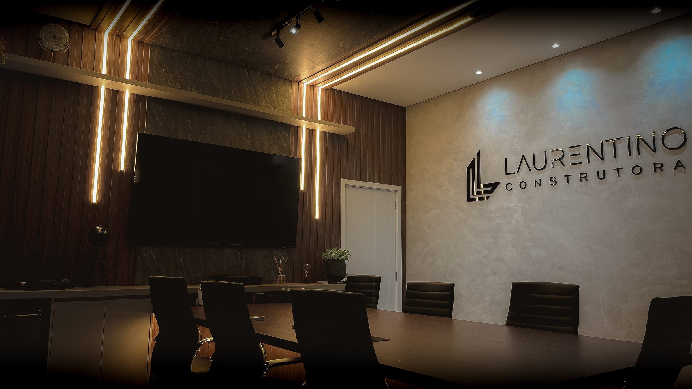 Sala de reuniões da Laurentino Construtora com o logo na parede